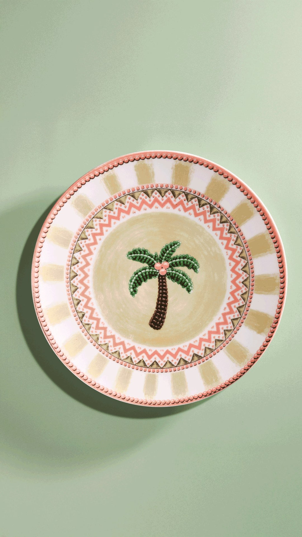 A Tale in Beads dinner plate photographed upright on sage green