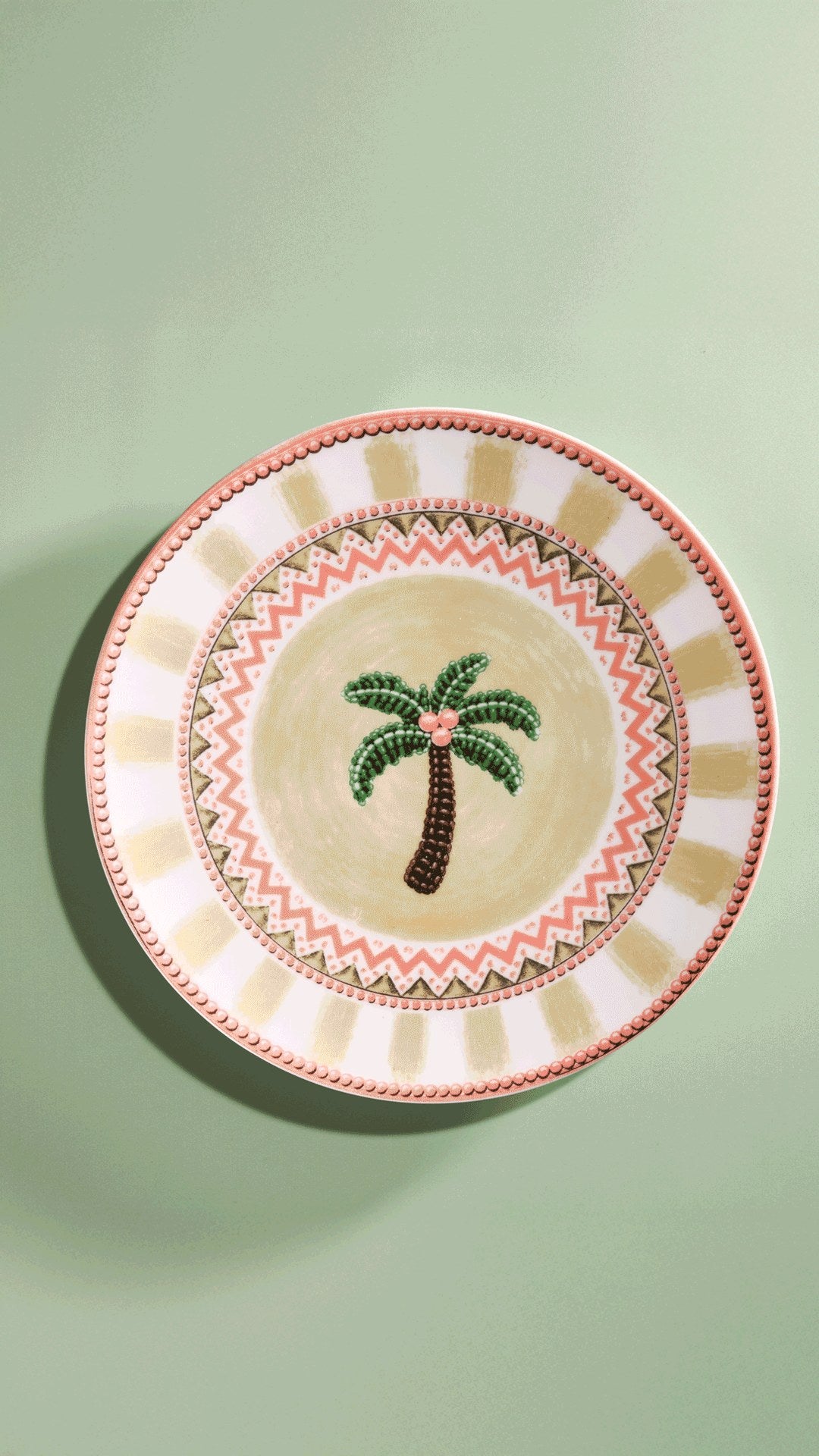 A Tale in Beads dinner plate photographed upright on sage green