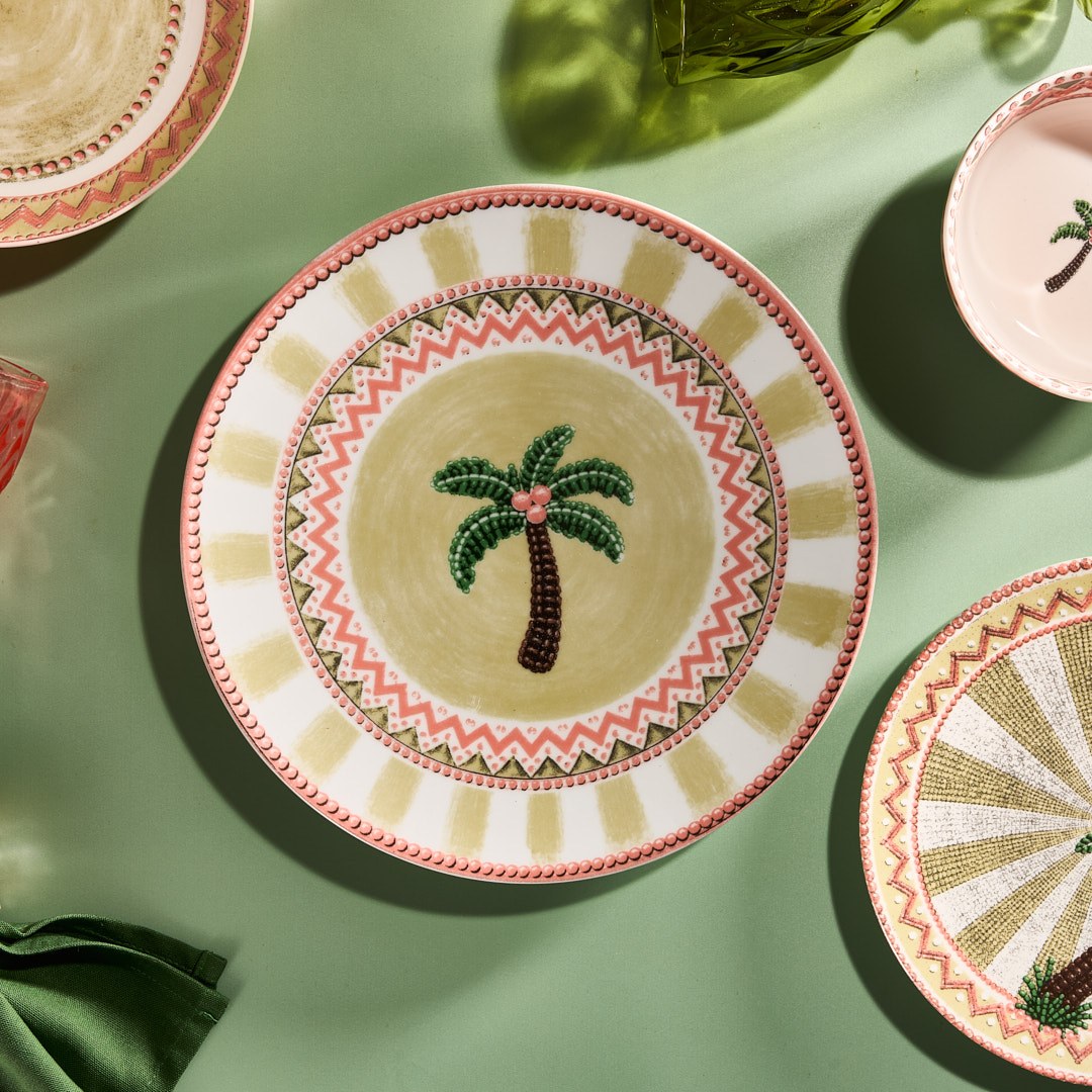 A Tale in Beads dinner plate and dessert plate arranged on sage green linen