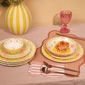 Pretty Past table styled with a yellow striped vase, pink glass and pasta served in a bowl