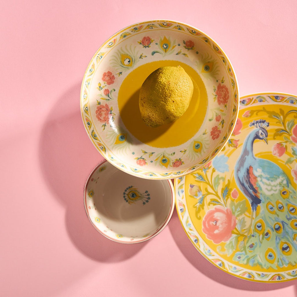 Pretty Past peacock plate with a saffron yellow soup bowl and a lemon on pink